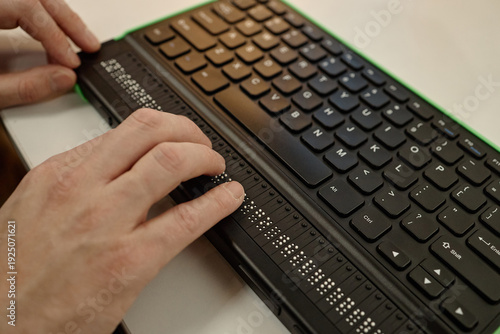 Fotografía Caucasian adult man using fingers to read braille display on electronic keyboard