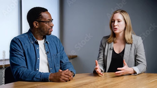 Two professionals having a discussion during a meeting at a modern office table.