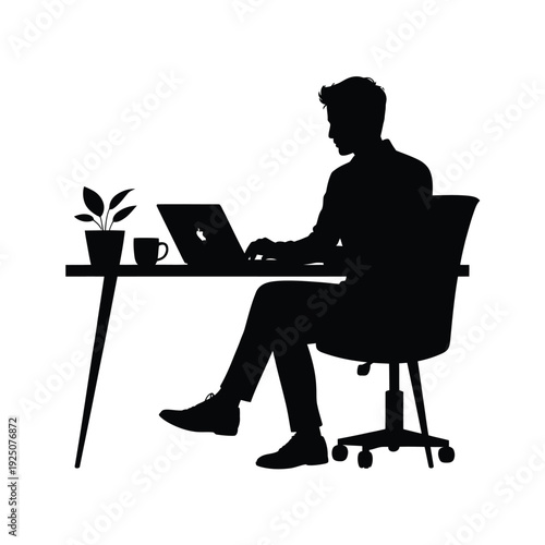 Silhouette of a man sitting at a desk using a laptop with a plant and