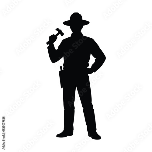 Silhouette of a cowboy holding a hammer standing confidently in a western style pose