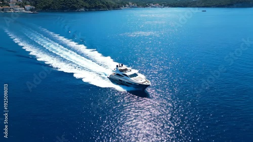 A motor yacht cruises across a sparkling turquoise ocean