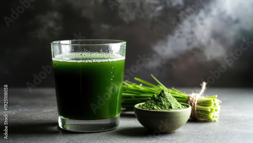Glass of green juice, powder in bowl, and fresh wheatgrass.