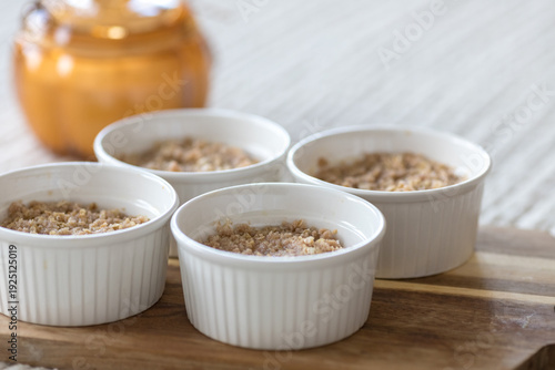 Portion of fruit crisp with oat topping on a textured tablecloth