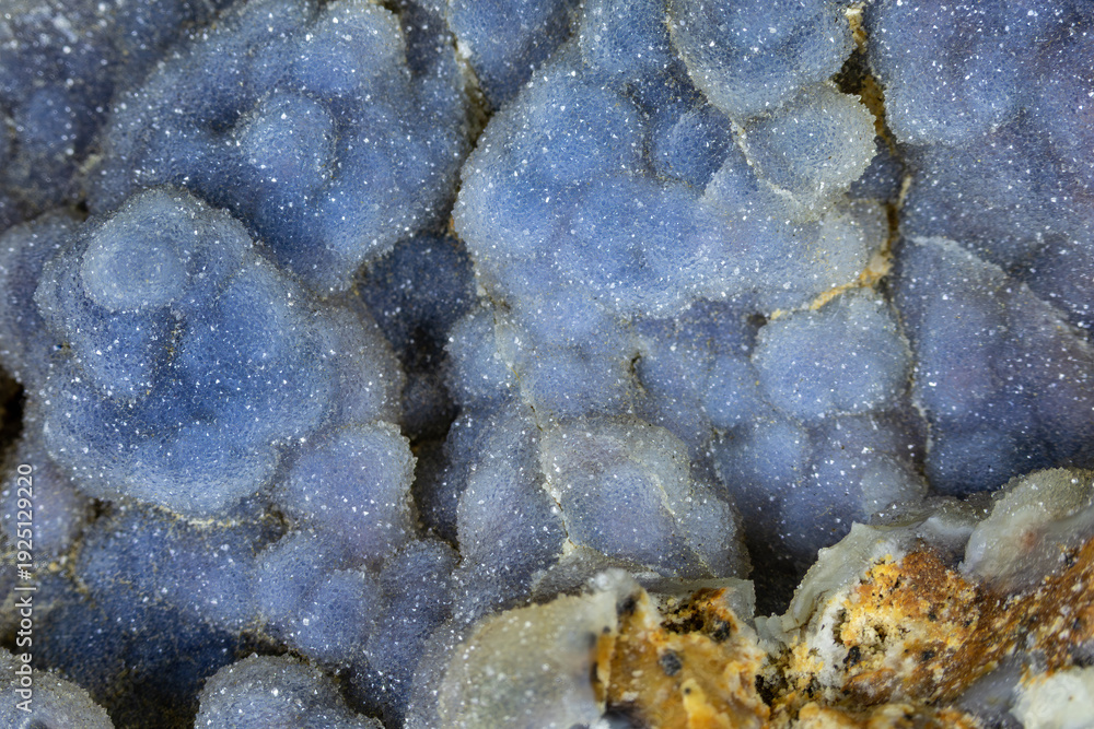 Fototapeta premium Closeup of blue druzy botryoidal quartz clusters. Host rock matrix in the foreground. 