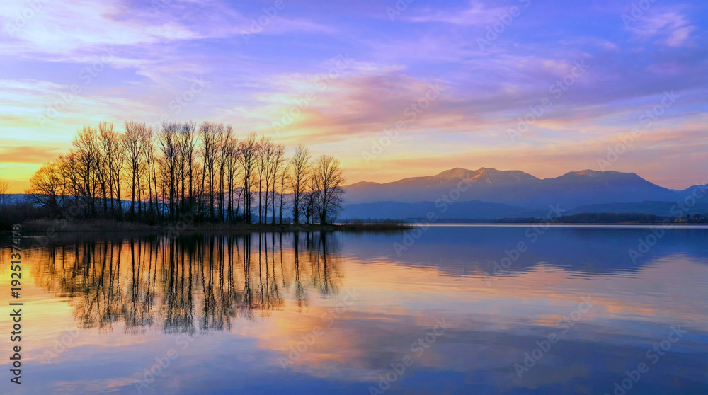 Fototapeta premium A serene lake at sunset with trees and mountains in the background