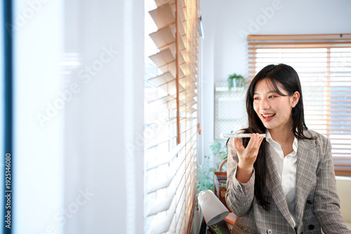 Asian businesswoman in a gray suit talking to voice assistant or chatbot on her smartphone in office, standing in modern office, using ai technology, smart assistant Free Download Asian businesswoman in a gray suit talking to voice assistant or chatbot on her smartphone in office, standing in modern office, using ai technology, smart assistant - GFXLoad