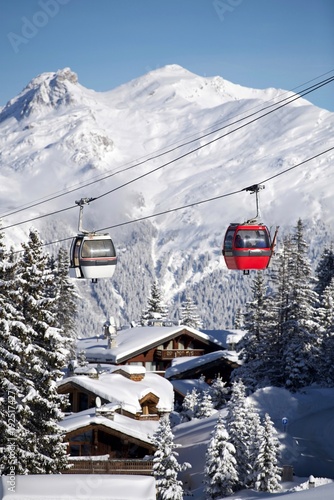 White and red Ski lifts over the slopes of Courchevel ski resort, French alps by winter