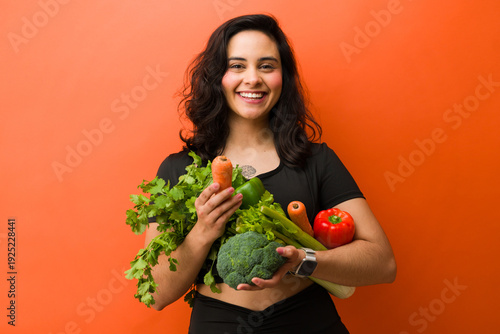 Fotografie Young woman smiling while holding fresh vegetables, living a healthy lifestyle f