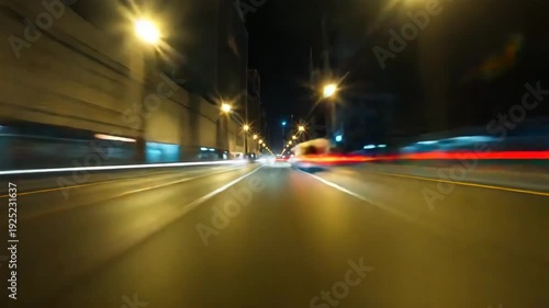 High speed night drive through illuminated urban tunnel with motion blur light streaks emphasizing rapid movement