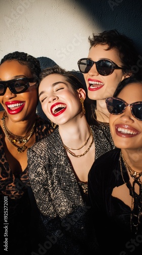 Group of stylish women laughing together in sunlight