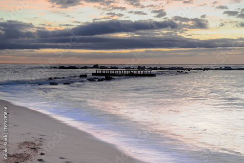 Amazing colourful sunrise seen over the Mediterranean Sea from Barceloneta Beach, which is located next to Barcelona's classic fishing quarter. It is the cities oldest and best-loved beach and gives w