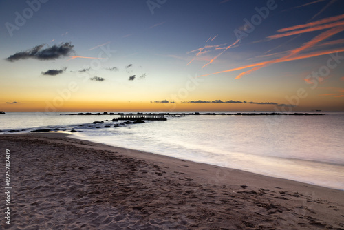 Amazing colourful sunrise seen over the Mediterranean Sea from Barceloneta Beach, which is located next to Barcelona's classic fishing quarter. It is the cities oldest and best-loved beach and gives w