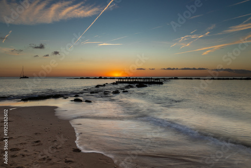 Amazing colourful sunrise seen over the Mediterranean Sea from Barceloneta Beach, which is located next to Barcelona's classic fishing quarter. It is the cities oldest and best-loved beach and gives w