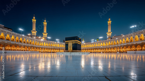 Illuminated kaaba at night with surrounding architecture and a clear dark blue sky above the scene