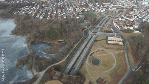 Wallpaper Mural Aerial drone footage showing vehicle traffic moving through a suburban area in Norway during late winter. The scene captures residential neighborhoods, roads, and surrounding landscape under cold seas Torontodigital.ca