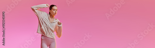 Photos Stylish woman dances joyfully against a vibrant pink background in trendy athlet