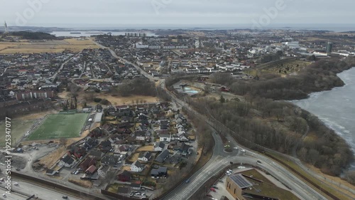 Wallpaper Mural Aerial drone footage showing vehicle traffic moving through a suburban area in Norway during late winter. The scene captures residential neighborhoods, roads, and surrounding landscape under cold seas Torontodigital.ca