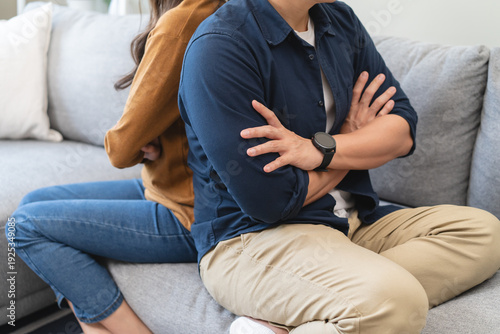 Family problem concept, Asian wife and husband sitting back to back in the living room at home have problems in a relationship and have an argument