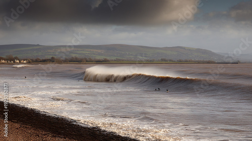 Surfers Riding a Large Wave on a Cloudy Coastal Shore