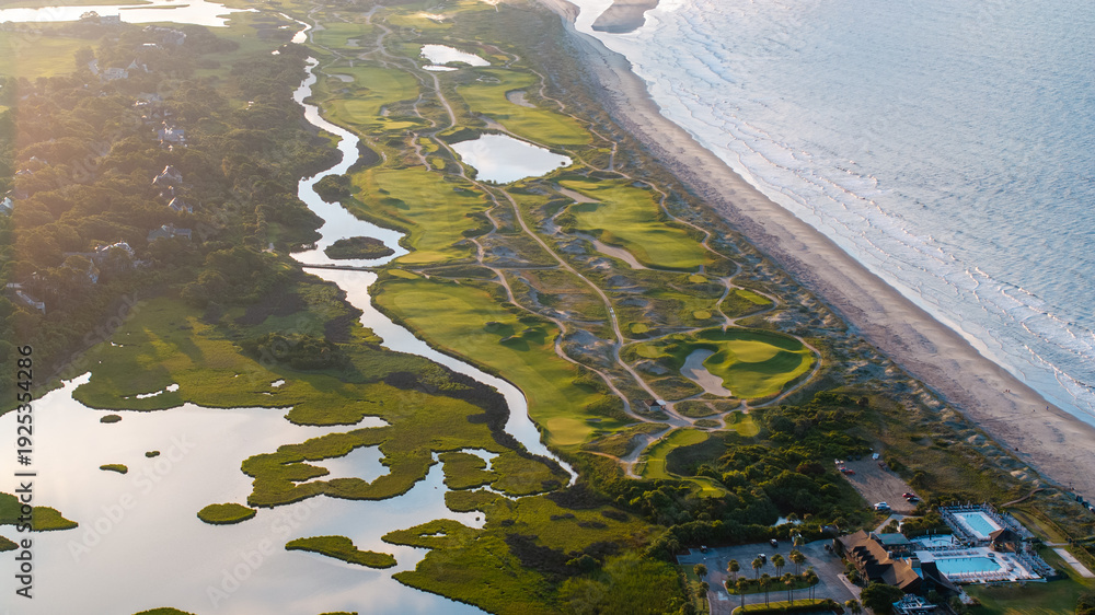 Fototapeta premium Aerial view of ocean golf course on Kiawah Island, South Carolina lowcountry landscapes with beachfront coastal views during morning sunrise