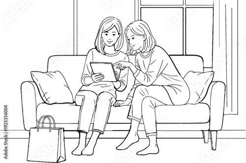 Two women sharing a digital tablet while sitting on a sofa indoors