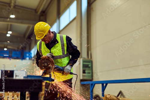 Foto Industrial Worker Grinding Metal in Warehouse Workshop Wearing Hard Hat And Hi-V