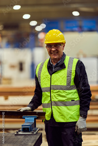 Smiling Construction Worker in Hard Hat and High Visibility Vest Inside Industrial Warehouse