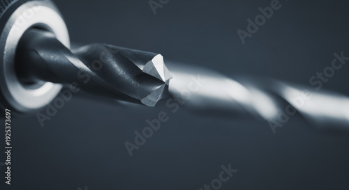 Close-up of a sharp metal drill bit rotating in a drill chuck, highlighting the precision engineering of this essential power tool accessory for drilling tasks.