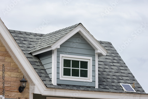 Fotografía A house with a slanted roof and a window on the top