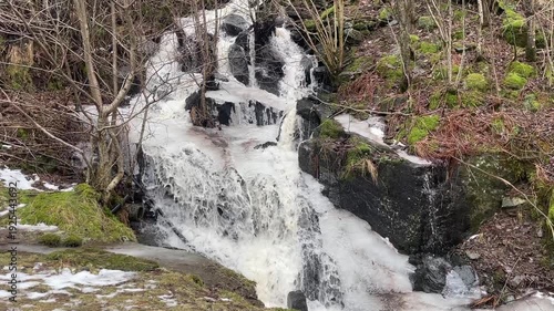 Waterfall flowing in the winter forest