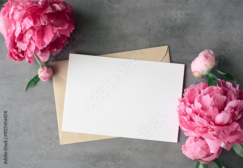Mock up card with peonies. Invitation card with envelope on grey background.