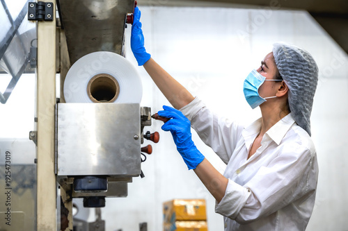 Female Asian food factory worker working on plastic packing in export frozen food manufacturing