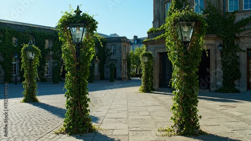 Ivy Covered Lampposts Line Cobblestone Courtyard in Front of Historic Stone Buildings