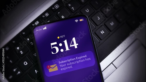 Smartphone shows subscription expired notification on laptop keyboard highlighting digital dependency in modern workspace, 4k
