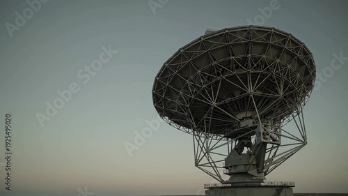 A high-angle shot of a massive metallic parabolic antenna used for space communication and astronomical research. This asset is perfect for themes involving science, global communication, and space ex