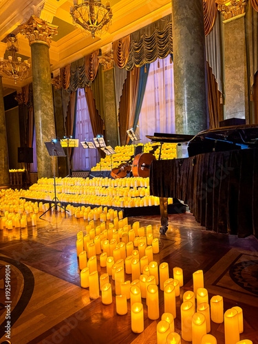 Grand piano surrounded by hundreds of candles in an elegant hall before a chamber concert.