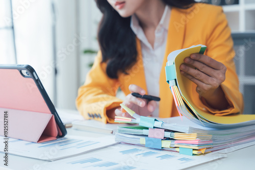 Focused Professional: An attentive professional, meticulously reviewing documents and utilizing modern technology within a focused work environment.