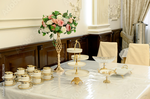 Canvas Print Elegant table setting with floral arrangement and fine china display