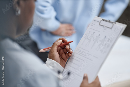 Cuadro en lienzo Black woman holding clipboard reviewing medical chart with anatomical diagrams w