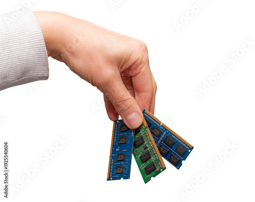 Hand holds several types of computer memory sticks including DRAM, DDR, SODIMM, and DIMM as a part of a hardware discussion