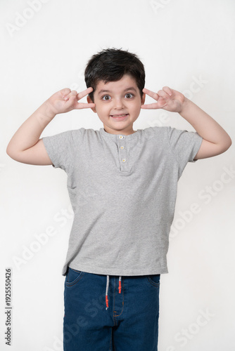 Playful Young Boy Making a Silly Face with Peace Signs