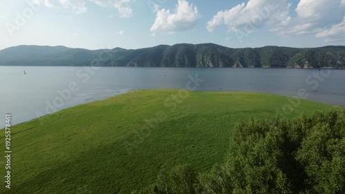 A lake in a national park in summer, birds flying over the water, filmed with a drone
