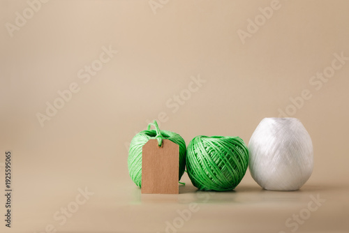 Various green and white spools of recycled polyester fiber with a blank label indicating the product's eco-friendliness. Recycling, conscious waste management