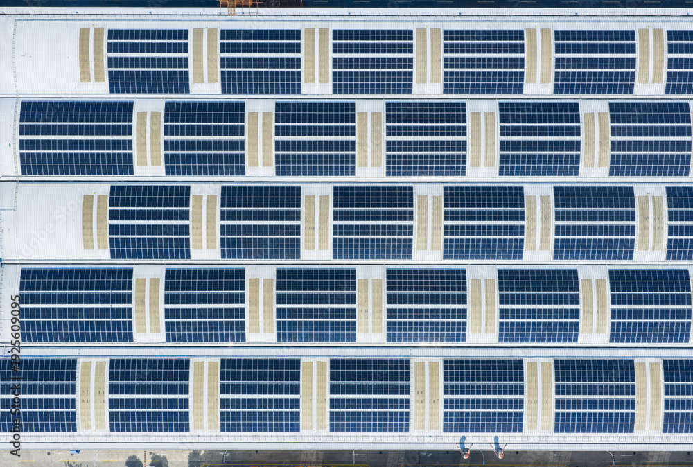 Fototapeta premium Aerial view directly above Solar panels on the roof of a station mall building