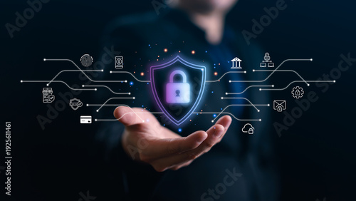 Businessman hand holding virtual shield with padlock and network icons. Concept of cyber security, data protection, privacy, and digital banking safety in futuristic corporate world.