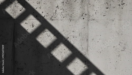A harsh geometric shadow from a repeating square pattern falls diagonally across a textured concrete wall surface.