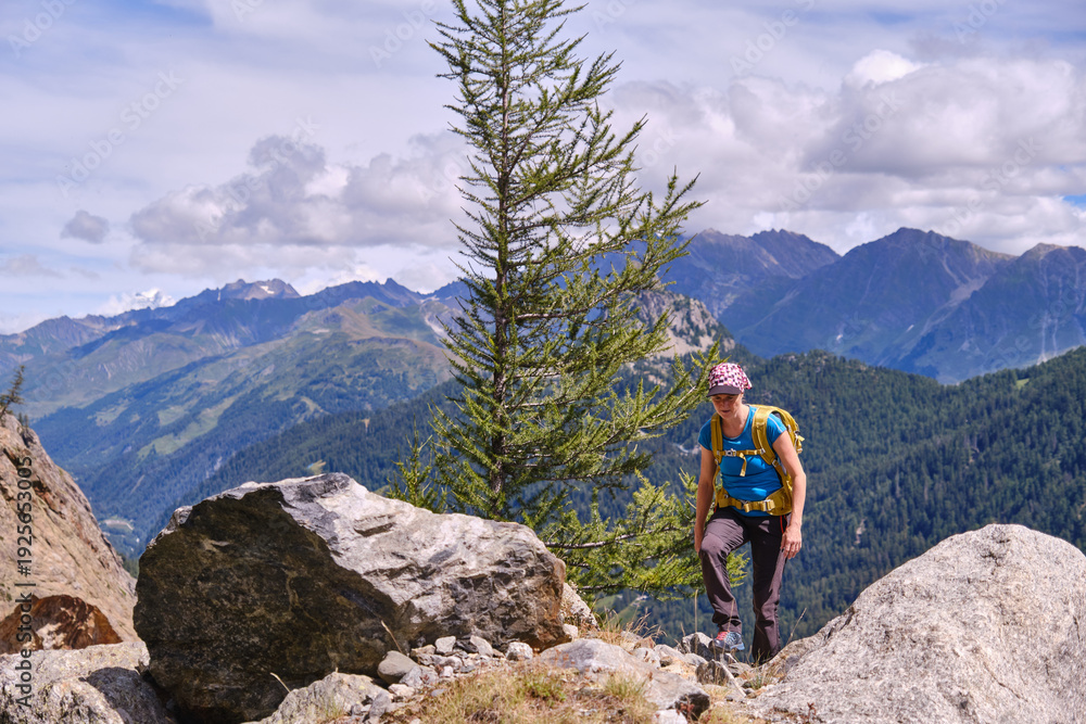 Fototapeta premium Woman hiker walking among rocks in the mountains