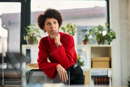 Obraz na plátně Confident young businesswoman reflecting in a modern office space