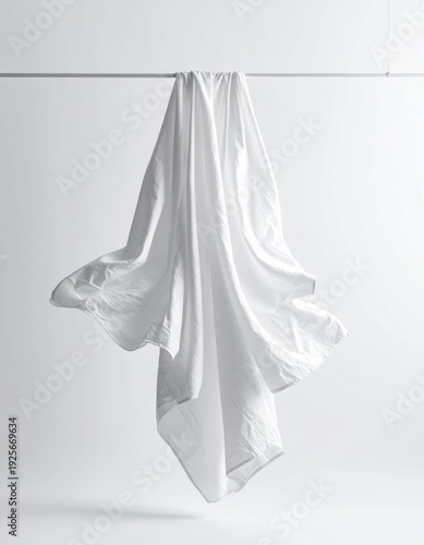 Hanging White Fabric with Textured Folds Against a Plain White Background