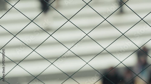 Chain link fence with blurry people crossing the road at Shibuya, Japan